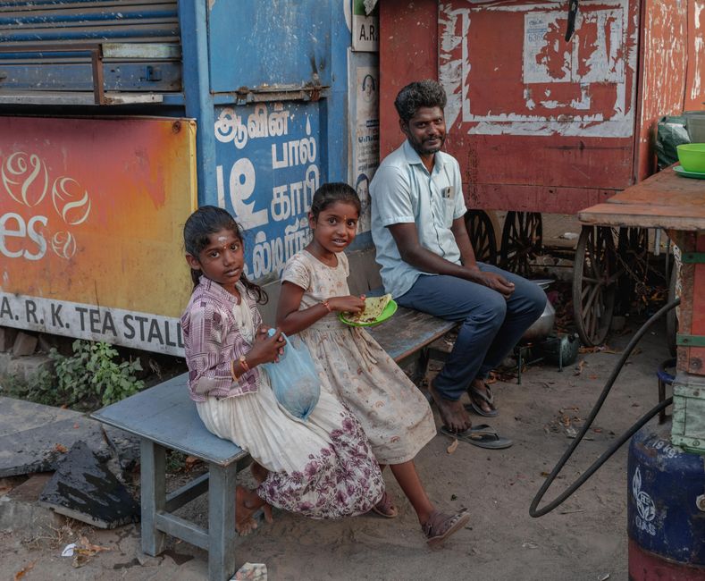 A candid street scene featuring people outside a tea stall in Kanchipuram, Tamil Nadu.