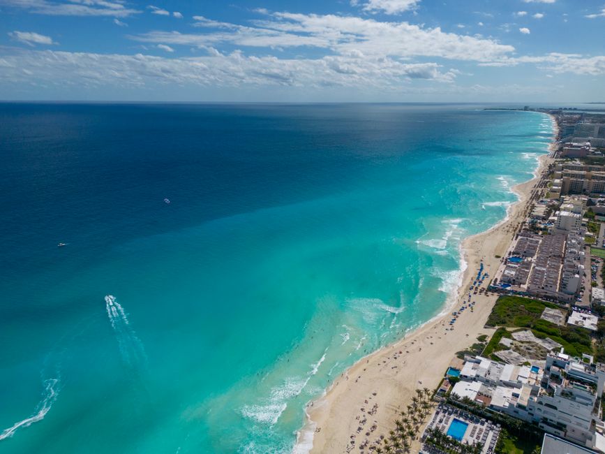 A breathtaking aerial view of Cancun's turquoise waters and sandy beaches lined with hotels.