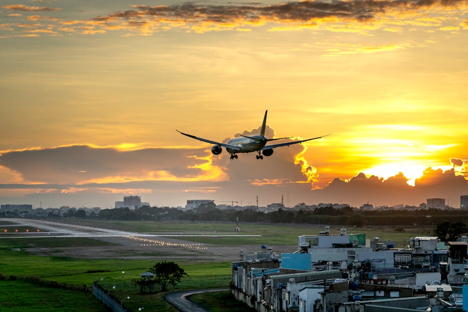 Airplane approaching runway during a vibrant sunset, perfect for travel and aviation themes.