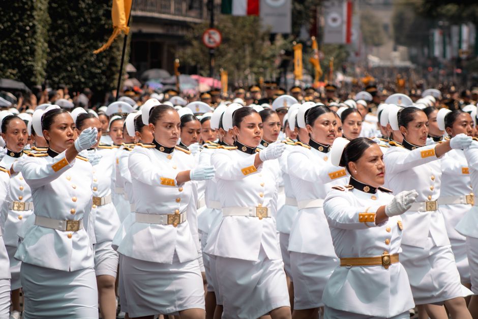 Female military cadets march in Mexico City's parade in crisp uniforms.