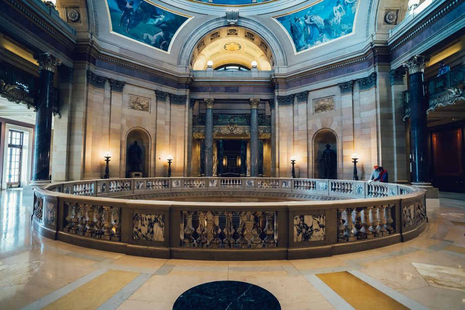 A stunning view of a grand museum hall with ornate columns and beautiful ceiling art.