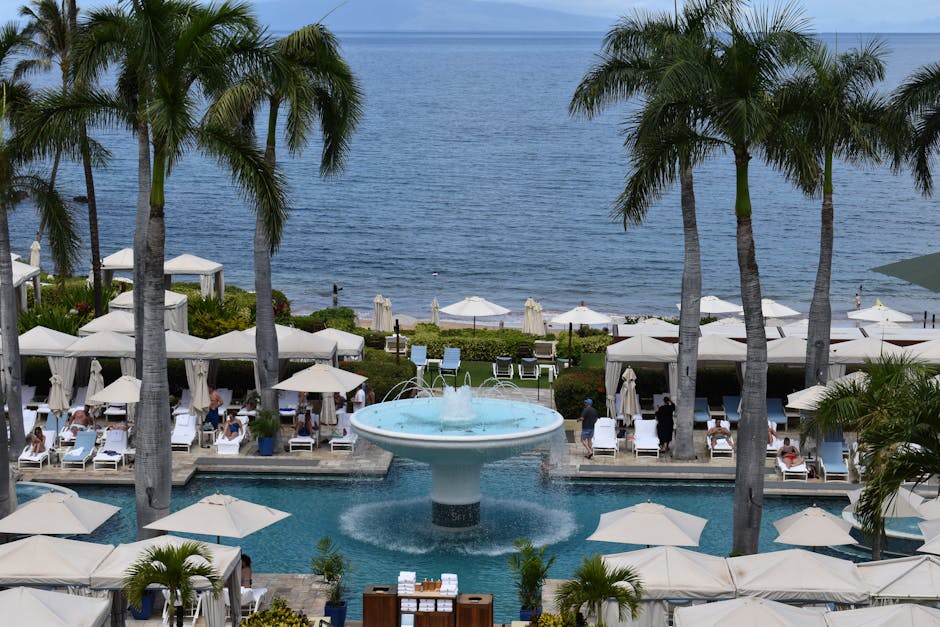 A stunning resort with a pool, palm trees, and ocean view, perfect for vacations.