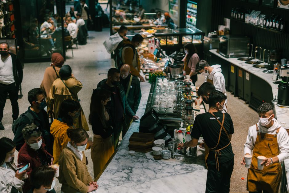 People gather in a lively coffee shop in Istanbul, showcasing baristas at work.