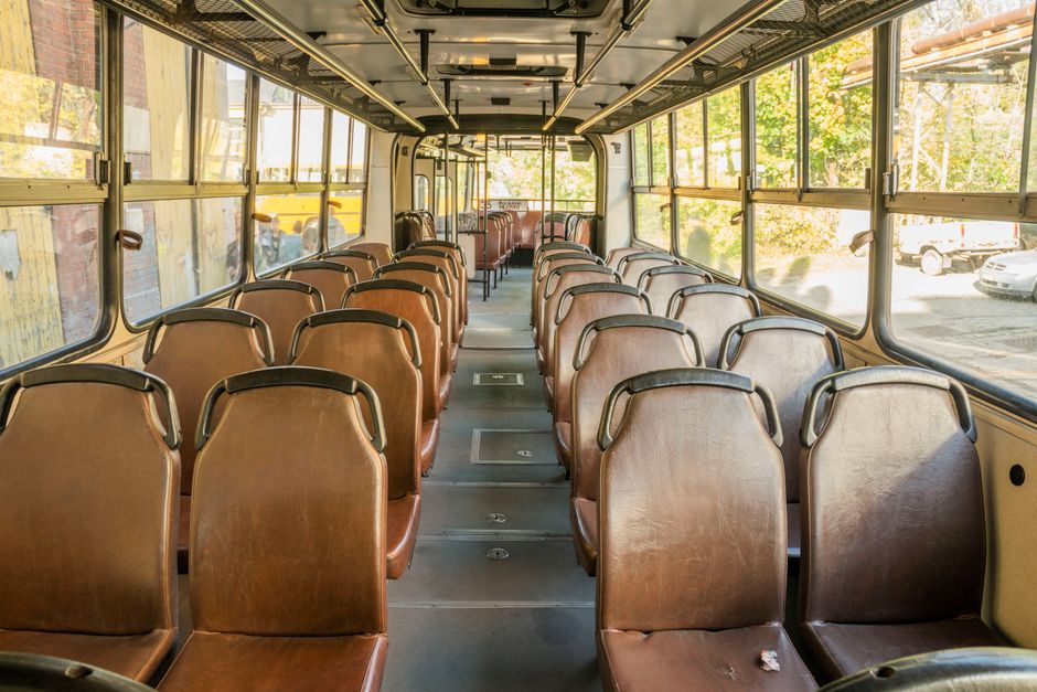 Interior view of an empty vintage bus in Wrocław, Poland, showcasing rows of brown seats.