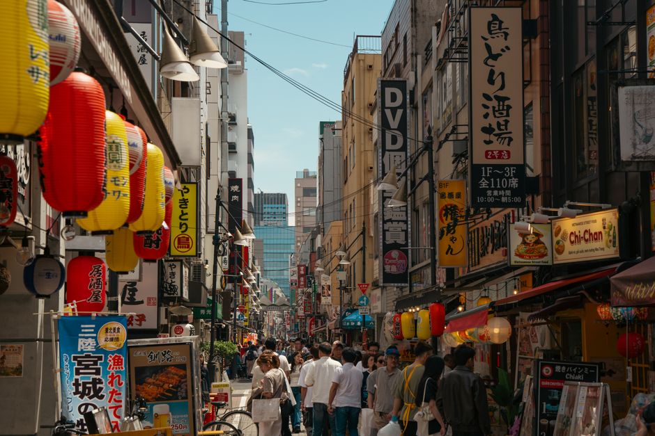 Busy Tokyo street with colorful lanterns and signage, showcasing urban life and culture.