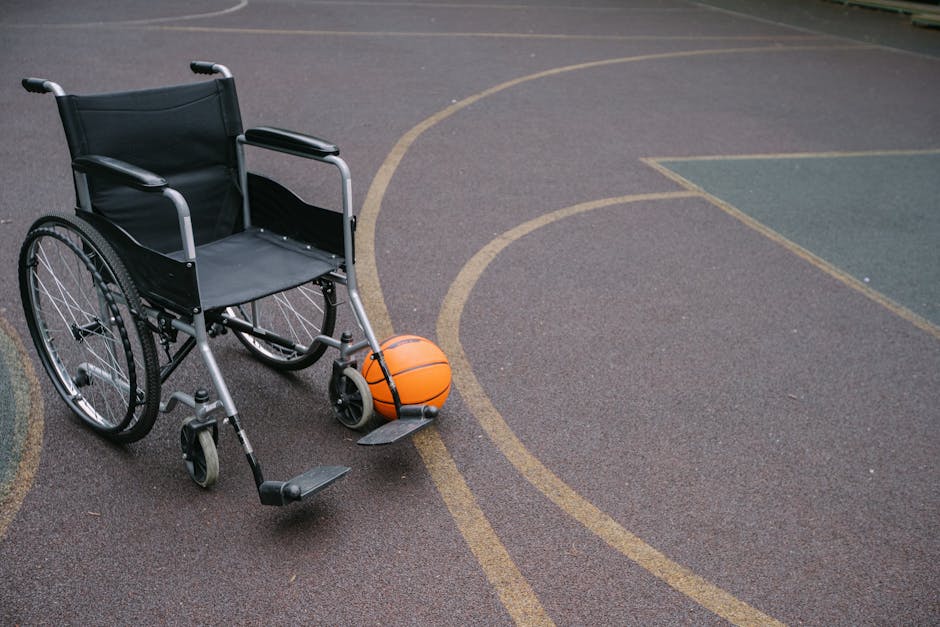 Wheelchair beside a basketball on an outdoor court highlights accessibility and sports.