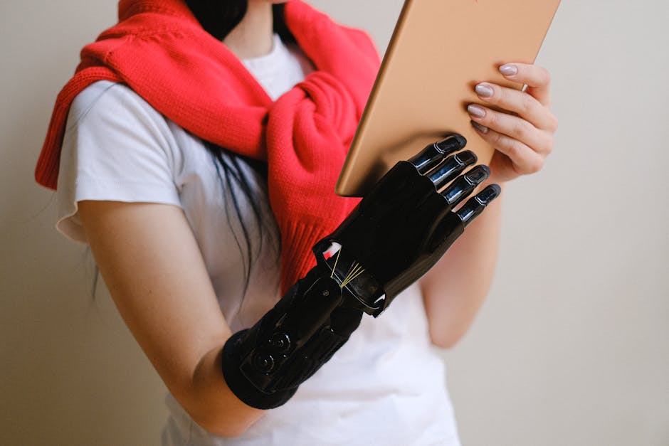 A person with a bionic hand holding a tablet, showcasing advanced prosthetic technology.