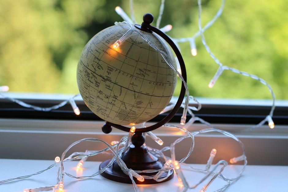A decorative globe surrounded by string lights, creating a warm ambiance on a window sill.